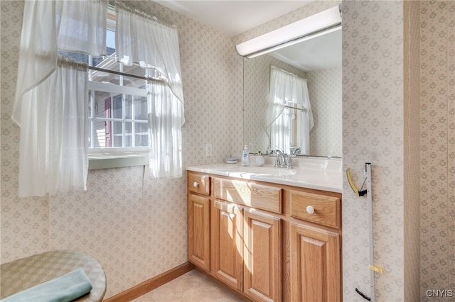 bathroom featuring a wealth of natural light, tile patterned flooring, vanity, and wallpapered walls