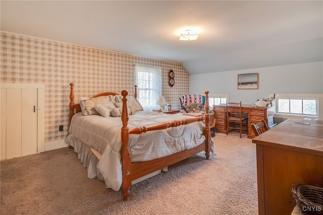 bedroom with wallpapered walls, lofted ceiling, multiple windows, and light colored carpet