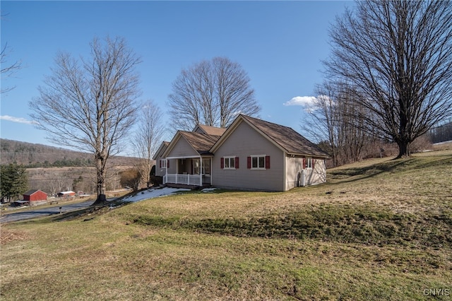 exterior space featuring covered porch and a front yard