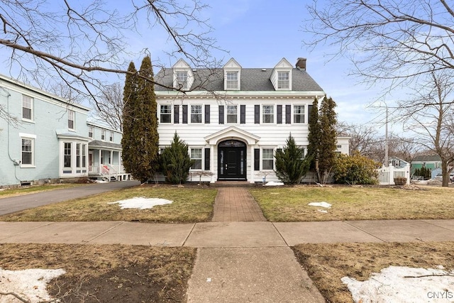 view of front of property with a front yard and a chimney