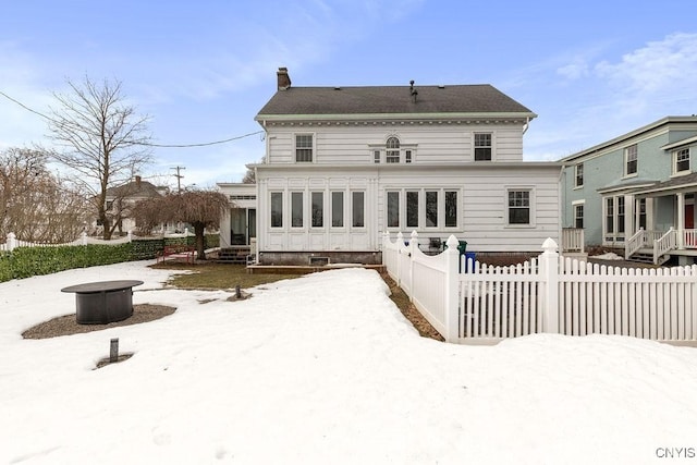 back of house featuring a chimney, a fire pit, and fence