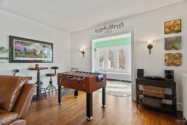 game room featuring radiator and wood finished floors