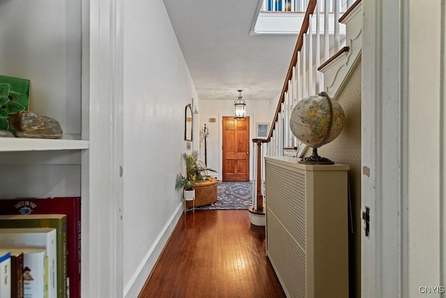 hallway featuring stairs, baseboards, and wood finished floors