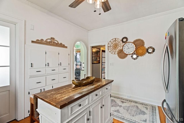 kitchen featuring white cabinetry, ceiling fan, ornamental molding, and freestanding refrigerator