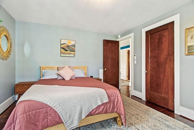 bedroom with baseboards and wood finished floors