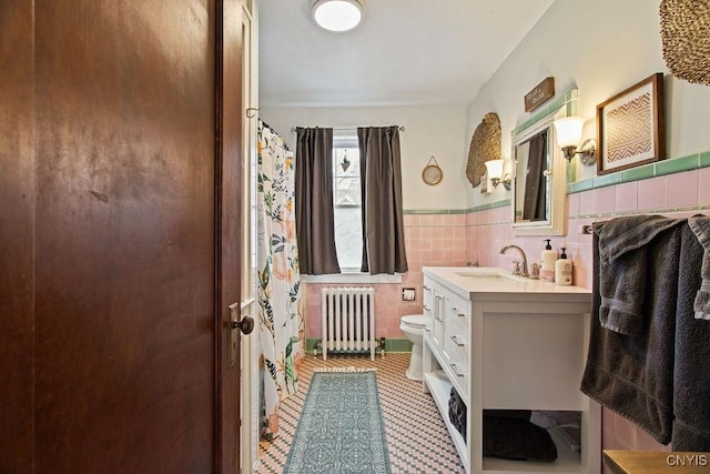 full bath featuring a wainscoted wall, toilet, radiator heating unit, tile walls, and vanity