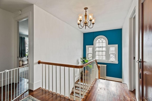 foyer featuring baseboards, a chandelier, and hardwood / wood-style flooring