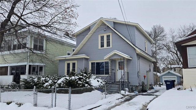 view of front facade featuring a fenced front yard, a detached garage, an outbuilding, and a gate