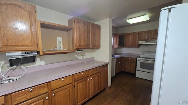 kitchen featuring dark wood finished floors, white appliances, light countertops, and under cabinet range hood