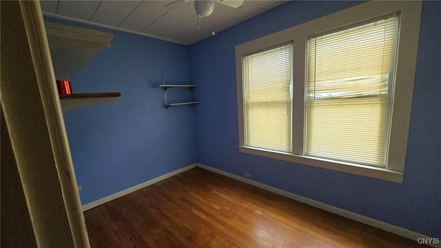 spare room with baseboards, a ceiling fan, and wood finished floors