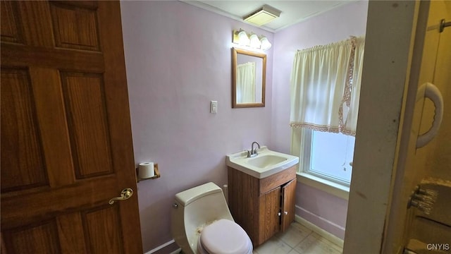 bathroom featuring toilet, vanity, and baseboards