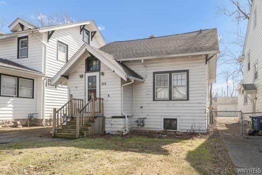 view of front of house with a front lawn, a gate, and fence