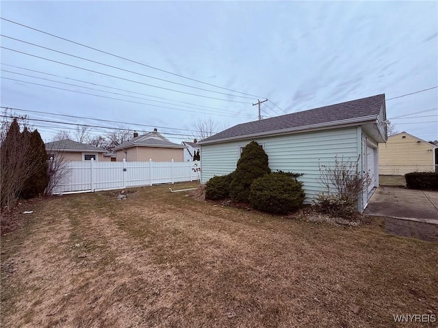 exterior space featuring a garage, a yard, and fence