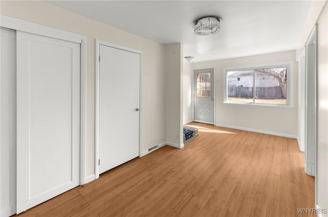 unfurnished bedroom featuring light wood-style flooring and baseboards