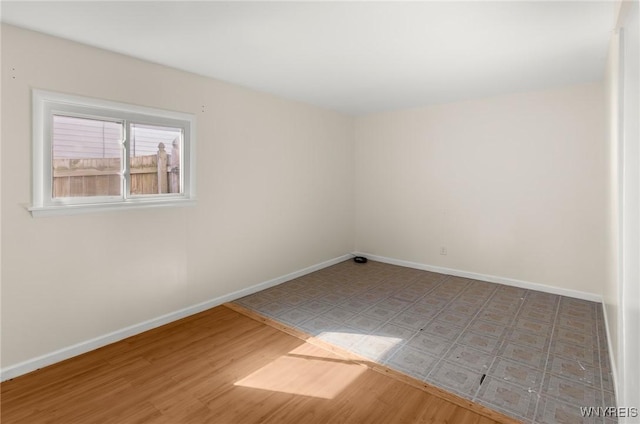 unfurnished room featuring baseboards and wood finished floors