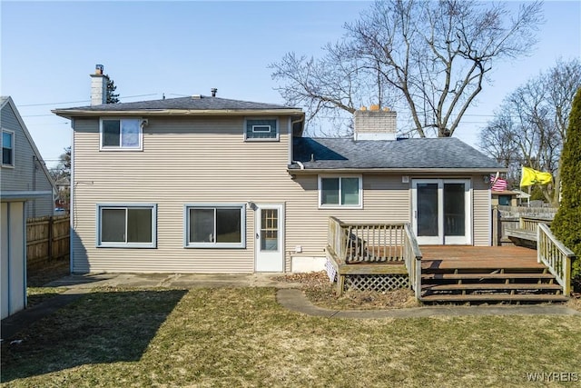 back of property featuring a deck, a chimney, a yard, and fence