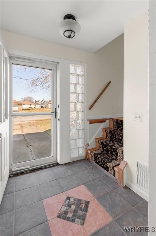 entryway with tile patterned floors, visible vents, and stairway