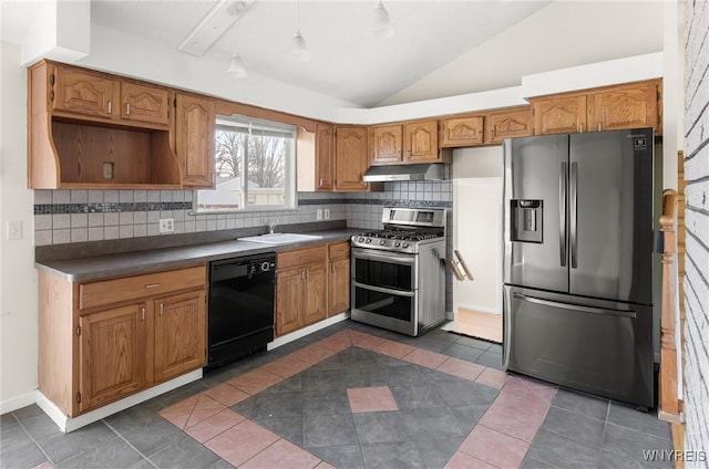 kitchen featuring under cabinet range hood, dark countertops, appliances with stainless steel finishes, and a sink