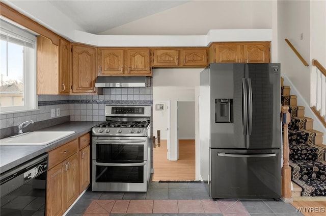 kitchen with ventilation hood, lofted ceiling, a sink, stainless steel appliances, and dark countertops