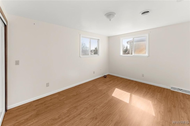 unfurnished room with visible vents, baseboards, and light wood-style floors