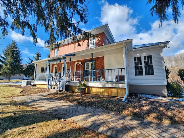 view of front of property featuring brick siding and covered porch