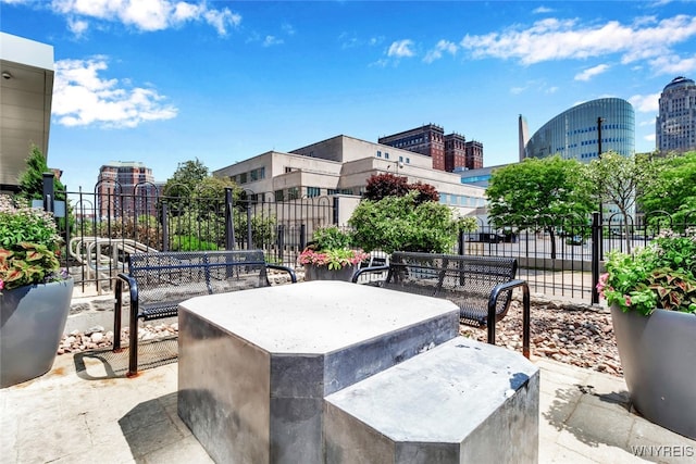 view of patio featuring a city view and fence