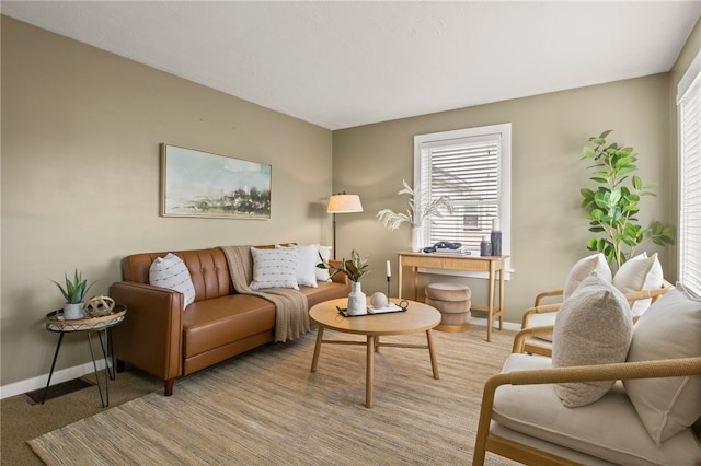 living area with baseboards and light carpet