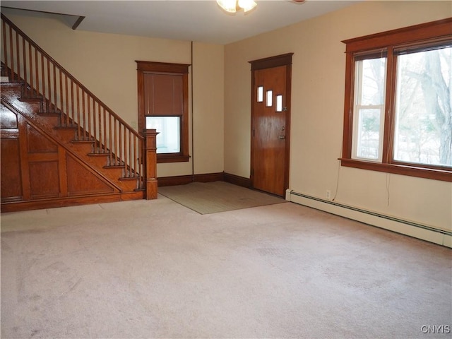 entryway featuring stairway, light carpet, baseboards, and a baseboard heating unit