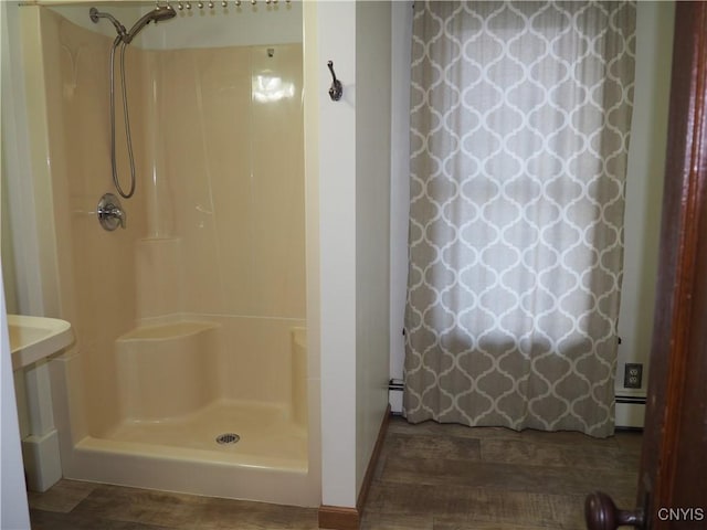 full bath with curtained shower and baseboard heating