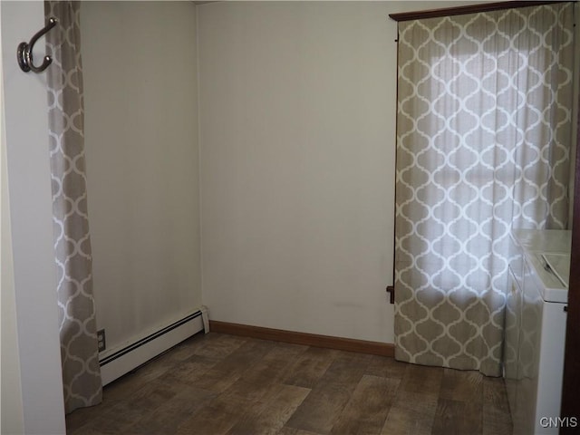 spare room featuring baseboards, washer / clothes dryer, baseboard heating, and dark wood finished floors