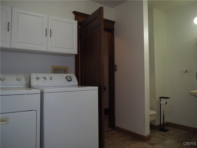 laundry room featuring baseboards, separate washer and dryer, and wood finished floors