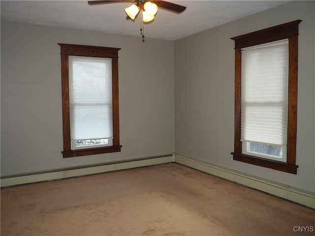 carpeted spare room with a baseboard heating unit and a ceiling fan