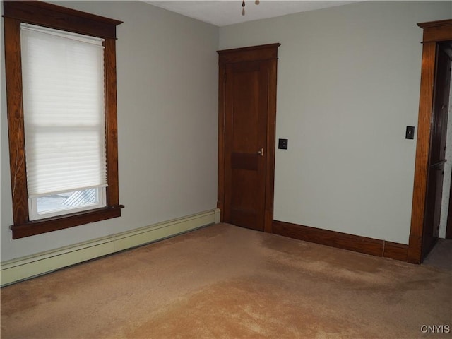 carpeted spare room featuring baseboards and a baseboard radiator