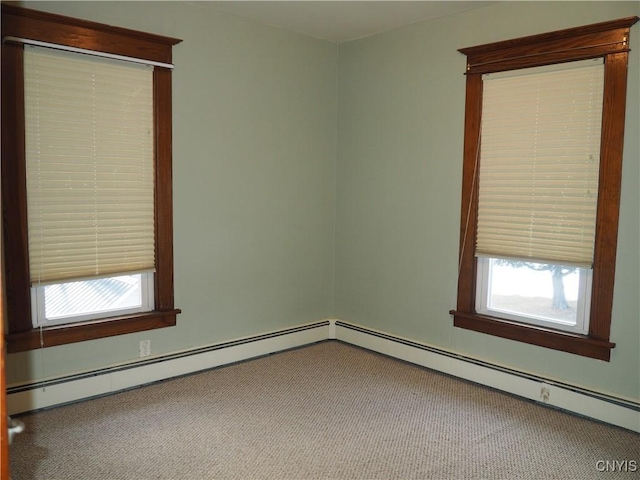 empty room featuring a baseboard radiator and carpet floors