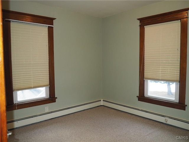 spare room with a baseboard heating unit and carpet