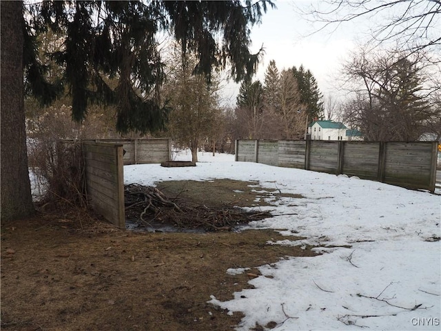 yard layered in snow featuring fence