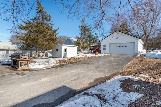 exterior space with an outbuilding, driveway, and a detached garage