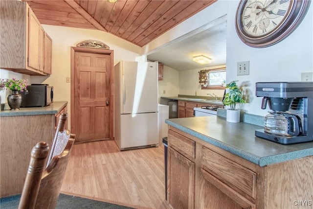 kitchen with vaulted ceiling, wooden ceiling, freestanding refrigerator, light wood-style floors, and a sink