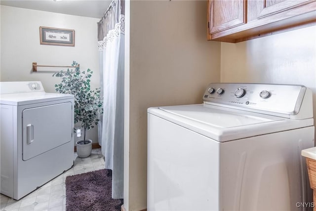 washroom with washer and dryer and cabinet space