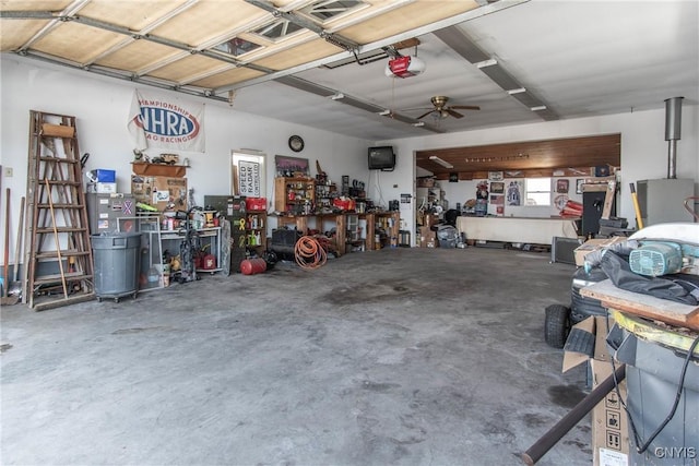 garage featuring a workshop area, a garage door opener, and ceiling fan