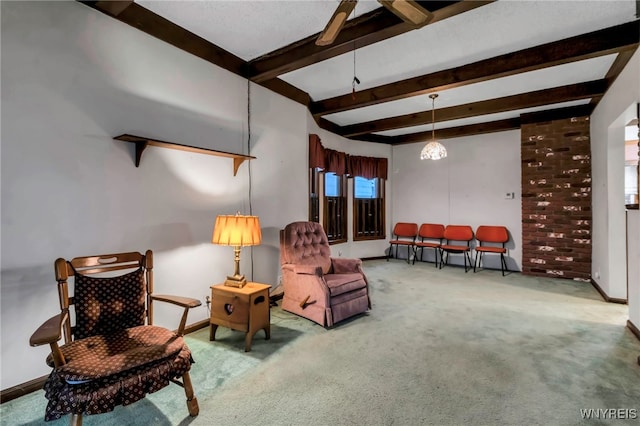 sitting room with baseboards, beam ceiling, and carpet flooring