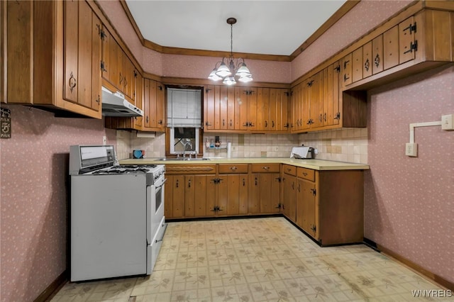 kitchen with light floors, wallpapered walls, a sink, under cabinet range hood, and white gas range