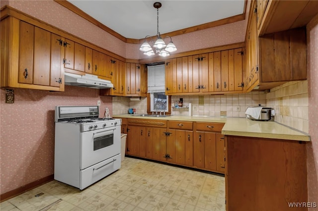 kitchen with wallpapered walls, white range with gas stovetop, light floors, and under cabinet range hood