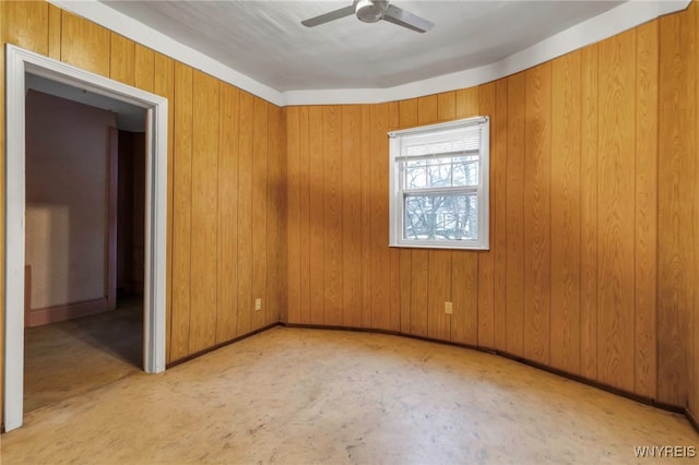 unfurnished room featuring a ceiling fan and baseboards