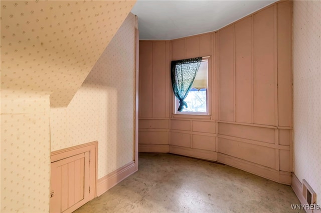 bonus room featuring visible vents, wallpapered walls, and concrete floors