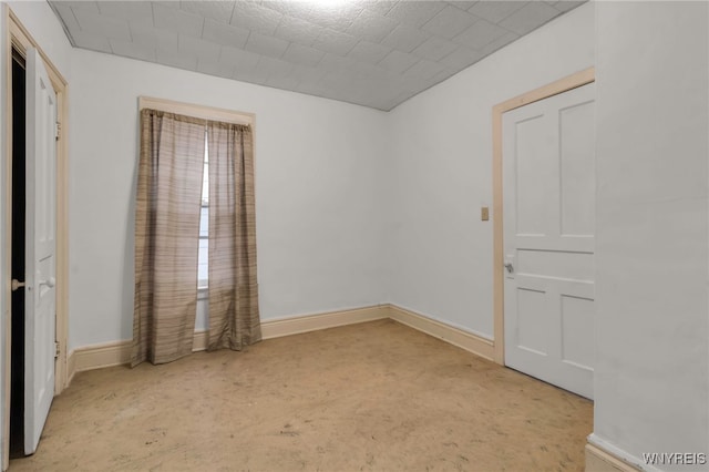 unfurnished room featuring baseboards and concrete floors