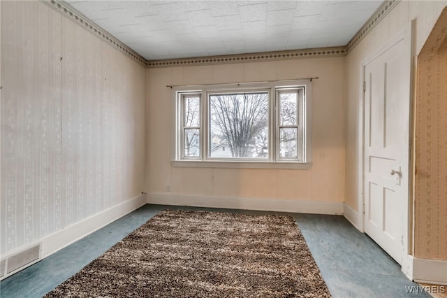 unfurnished room with visible vents, wallpapered walls, carpet, and baseboards