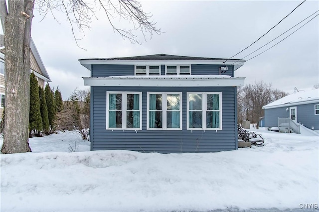 view of snow covered rear of property