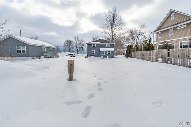 yard layered in snow featuring fence