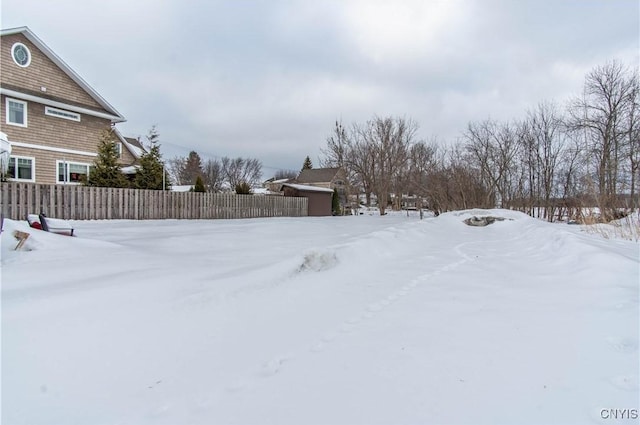 yard layered in snow with fence